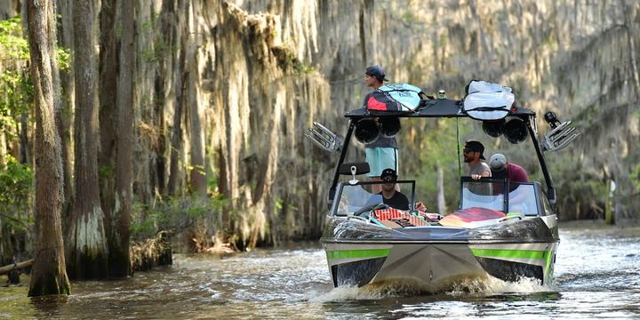 guys on wakesurf boat in swamp