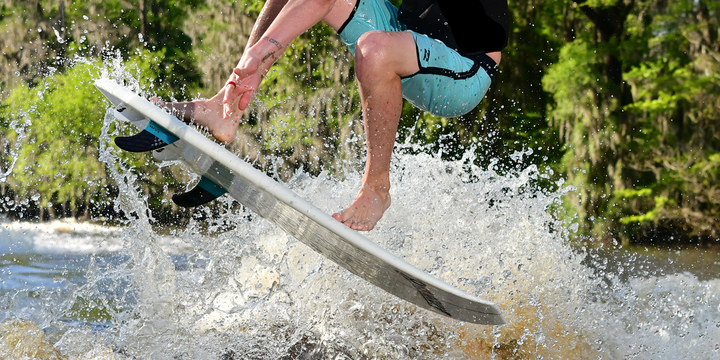 guy doing trick on doomswell wakesurf board