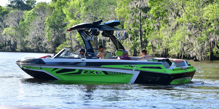 green wakesurf boat on the water
